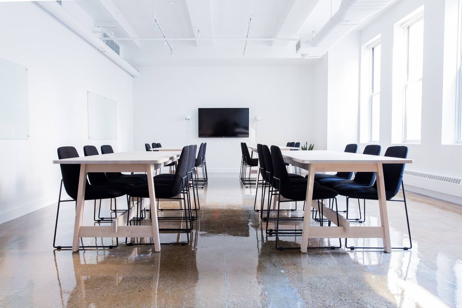 Tables and chairs arranged in a bright boardroom