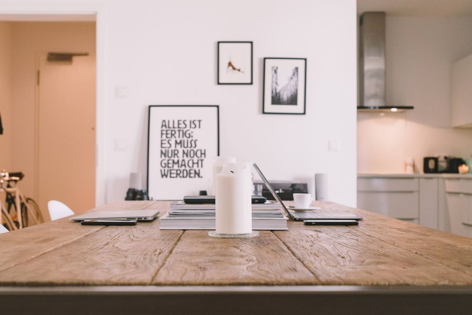 A wooden table top set against a white wall